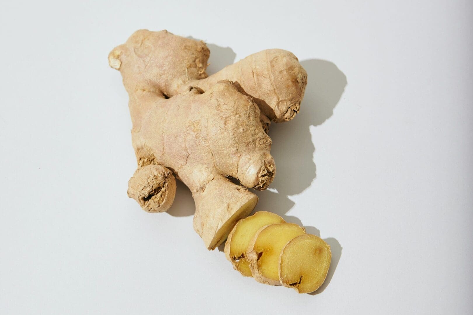 A peeled banana and ginger root on the table.