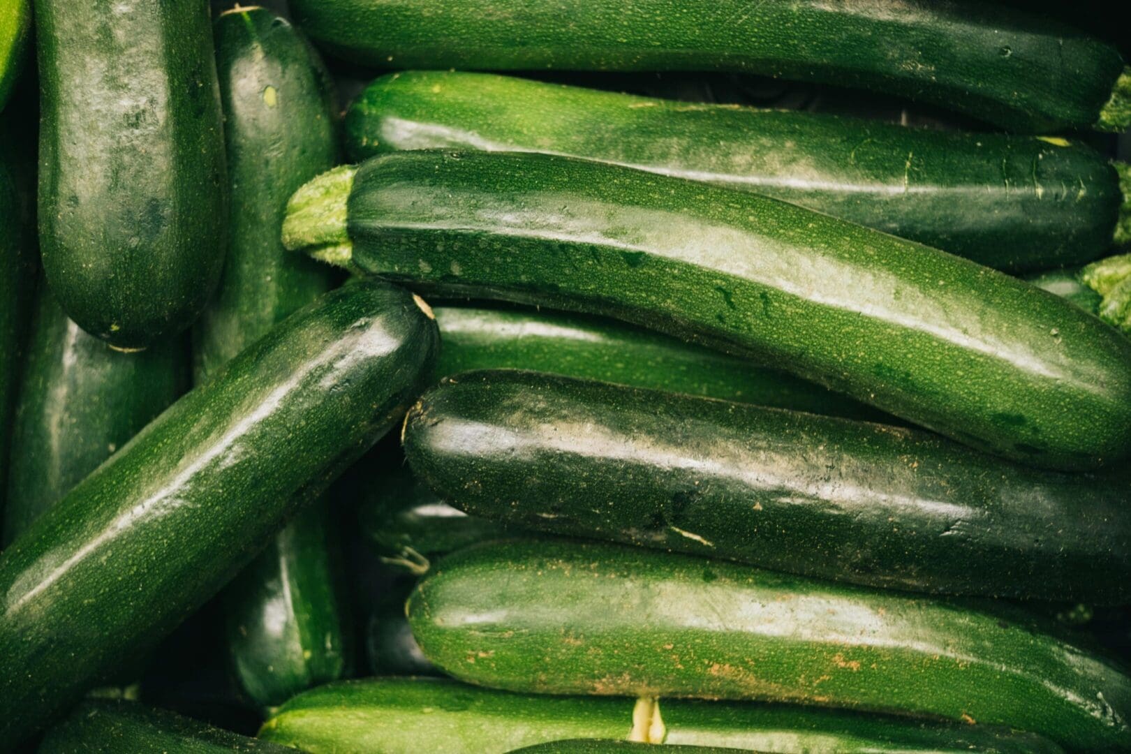 A pile of cucumbers sitting next to each other.